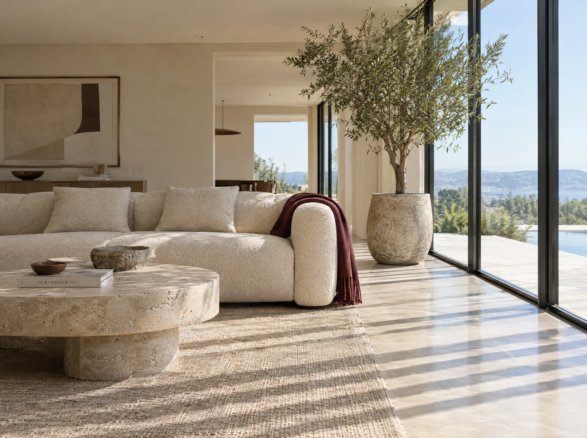 A calm bone living room with sculptural furniture and daylight through full height glass